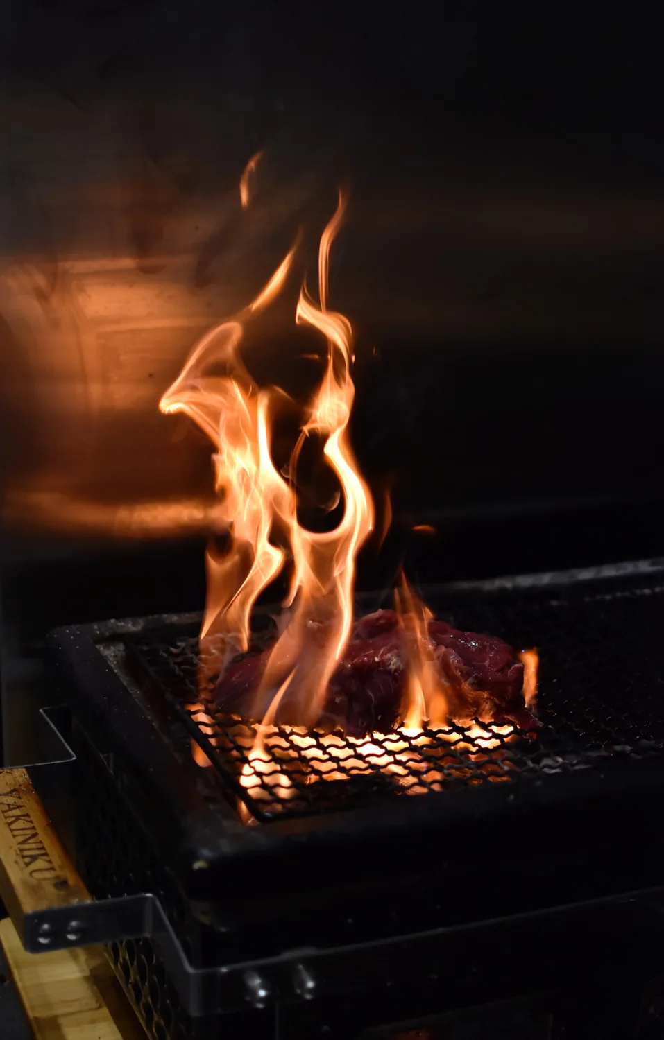 Vlammen op de houtskoolgrill in de keuken van Roots
