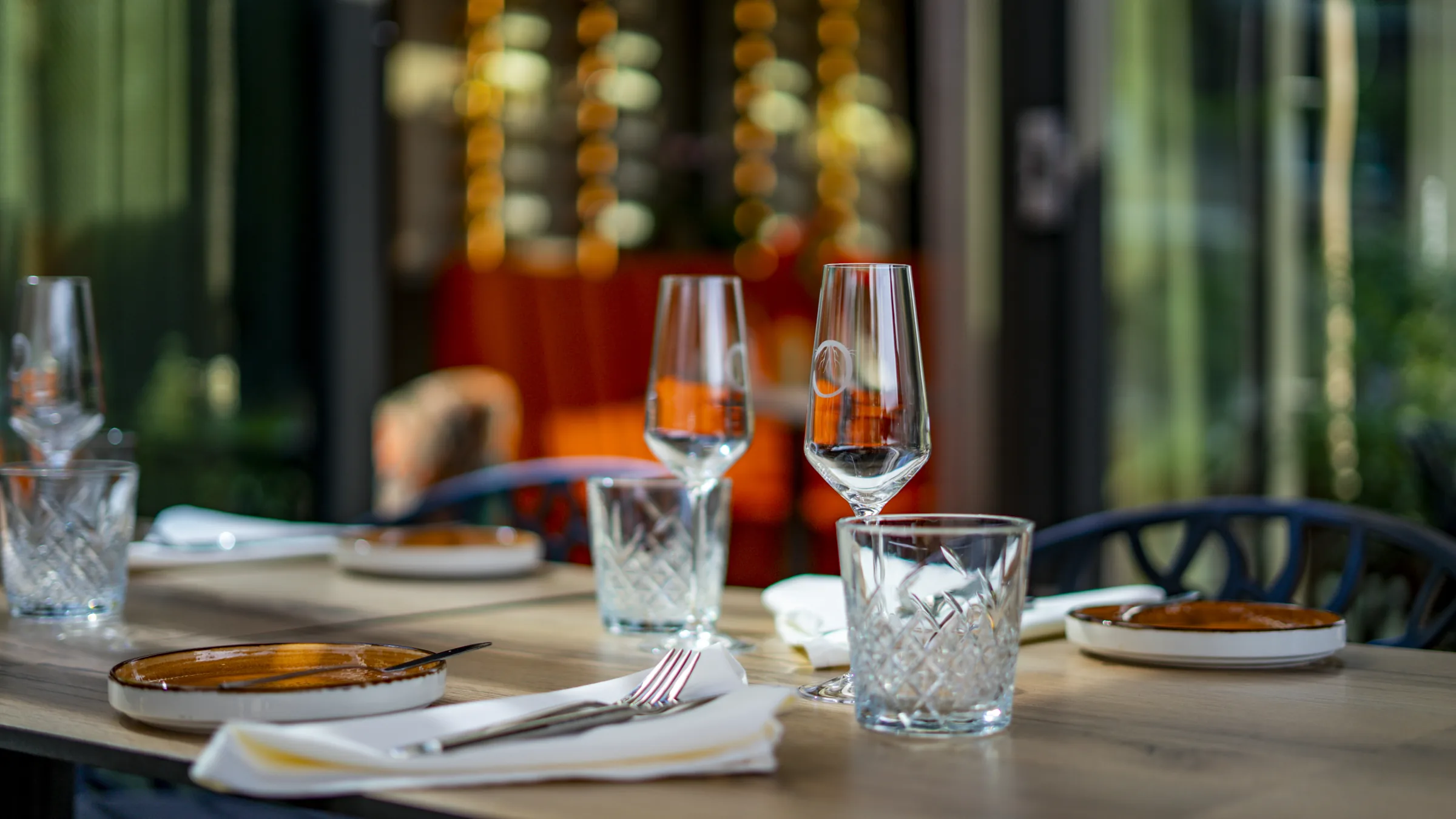 Warm gedekte tafel bij Roots met wijnglazen in sfeervol avondlicht